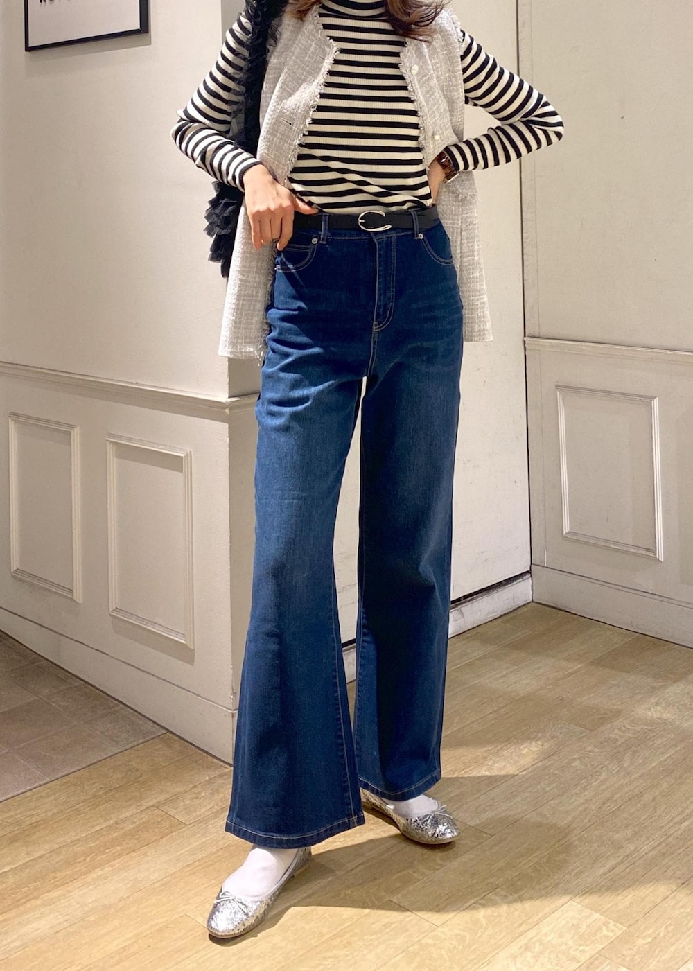 ブルー系のデニムパンツ、ブラック系のベスト、シルバー系のバレエシューズを着用したレディースの冬コーディネートの7枚目の写真