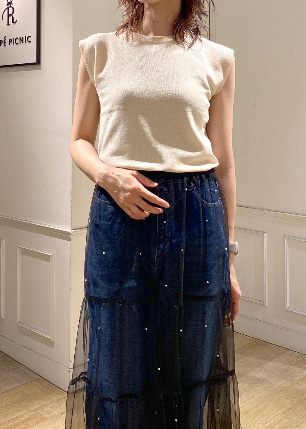 ブラック系のスカート、ブラック系のサンダル、ベージュ系のニット/セーターを着用したレディースの夏コーディネートの5枚目の写真