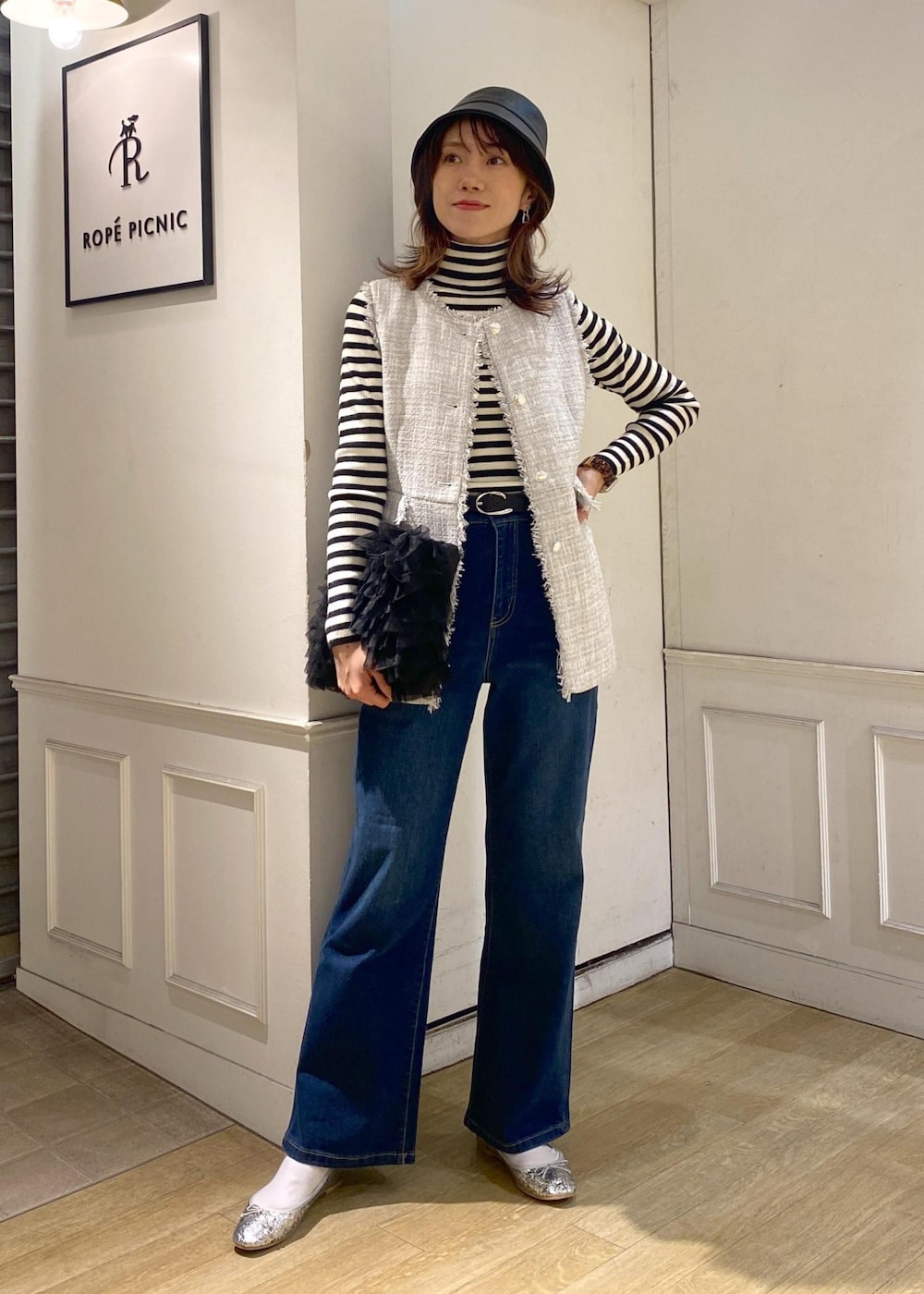 ブルー系のデニムパンツ、ブラック系のベスト、シルバー系のバレエシューズを着用したレディースの冬コーディネートの3枚目の写真