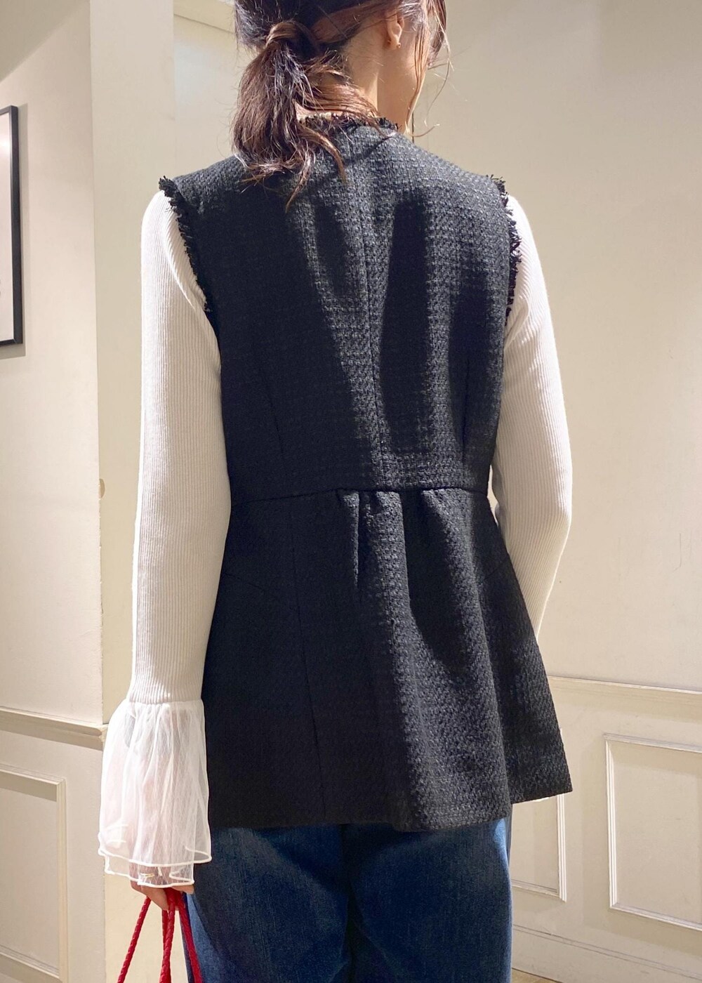 ブルー系のデニムパンツ、グレー系のニット/セーター、レッド系のトートバッグを着用したレディースの秋コーディネートの6枚目の写真