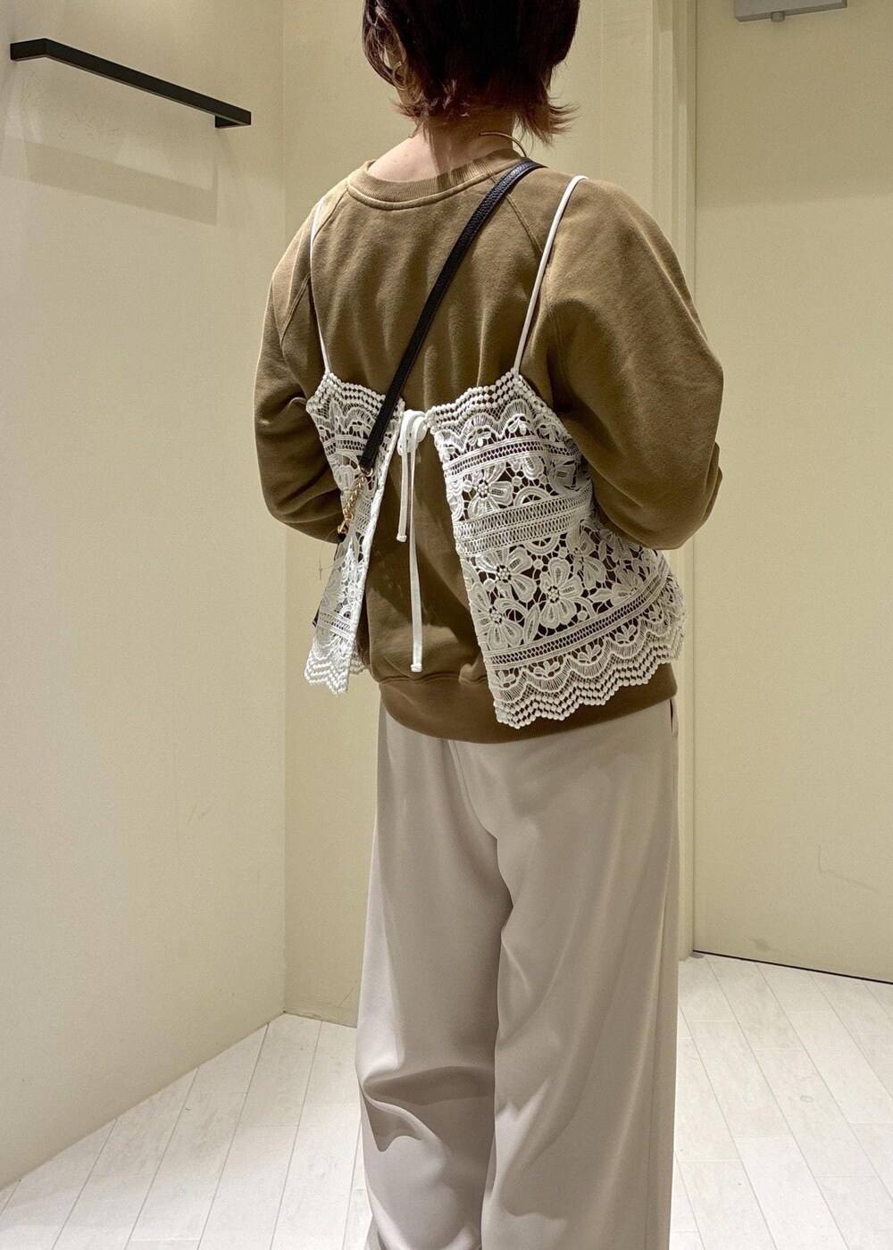 ブラック系のショルダーバッグ、ブラウン系のスウェット、ベージュ系のその他パンツを着用したレディースの春コーディネートの7枚目の写真