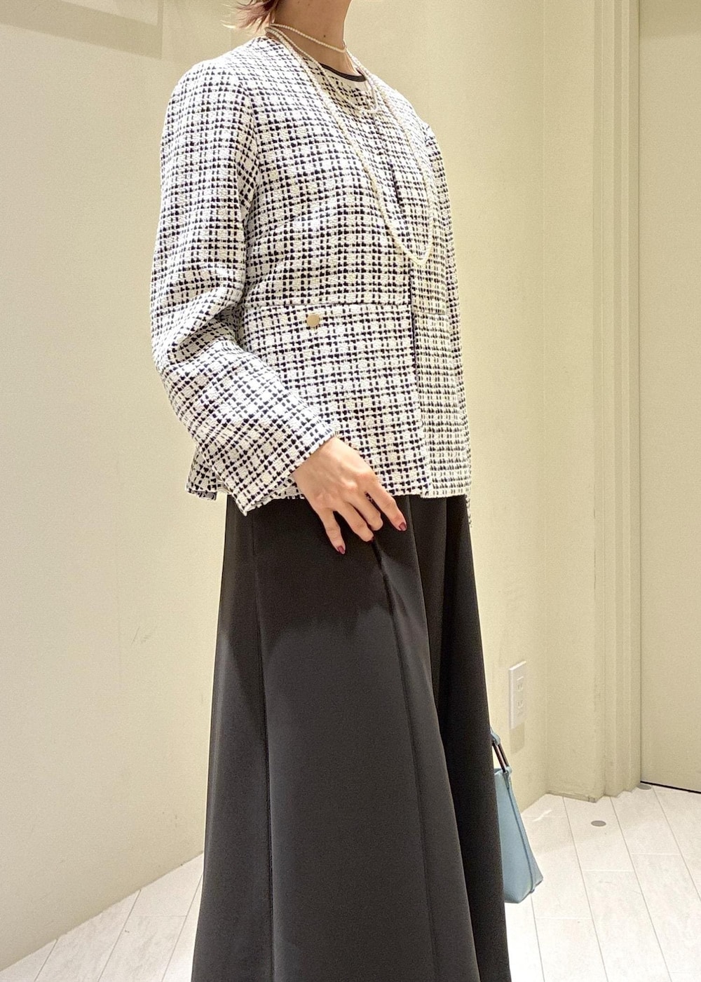 ブラック系のパンプス、ブルー系のショルダーバッグ、グレー系のドレスを着用したレディースの冬コーディネートの5枚目の写真