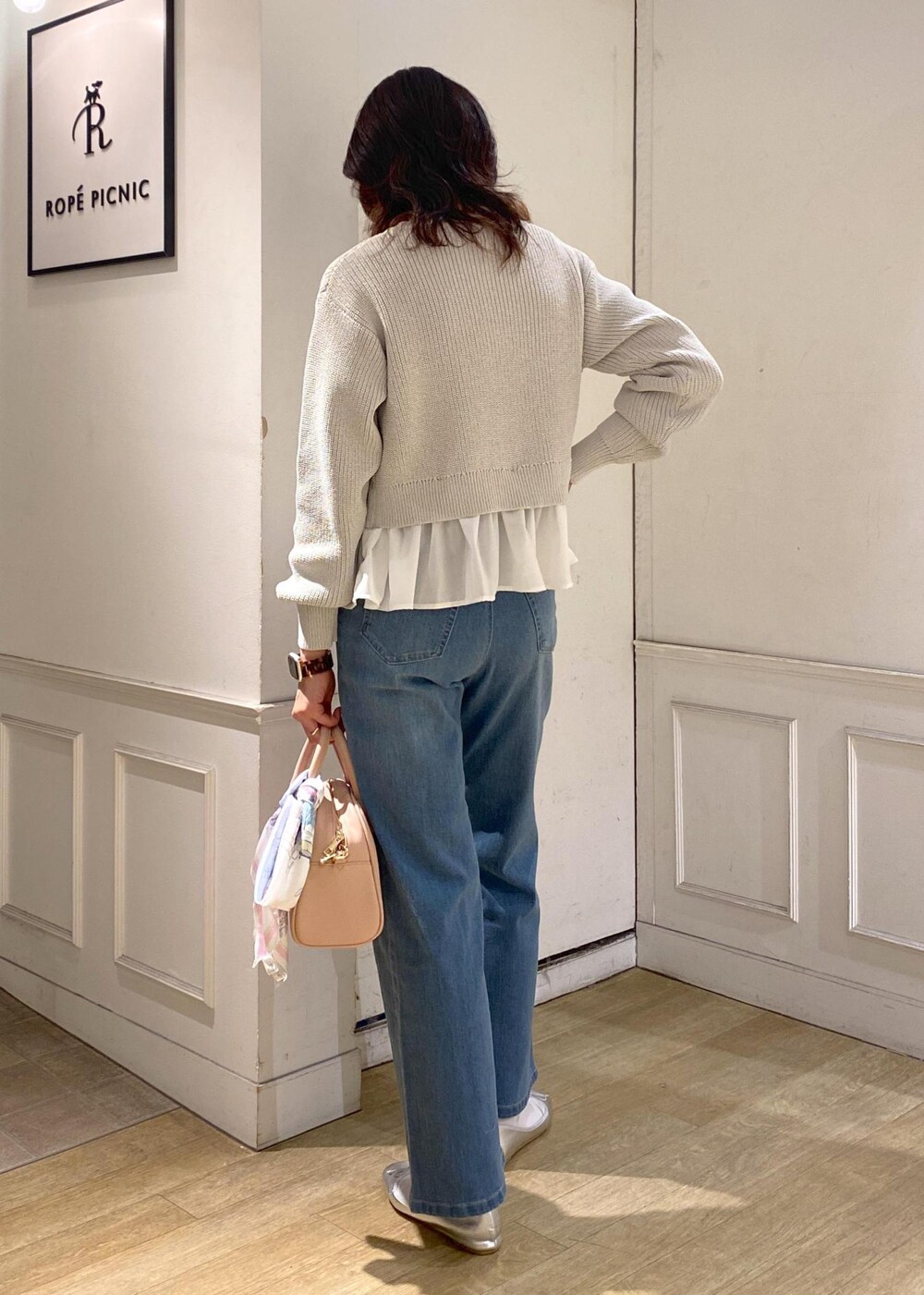 ブルー系のデニムパンツ、ピンク系のボストンバッグ、シルバー系のバレエシューズを着用したレディースの冬コーディネートの4枚目の写真
