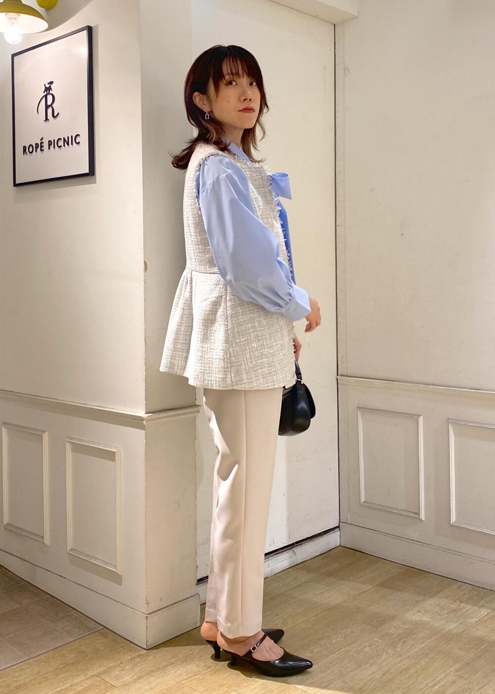 グレー系のベスト、イエロー系のその他パンツ、ブルー系のシャツ/ブラウスを着用したレディースの冬コーディネートの3枚目の写真