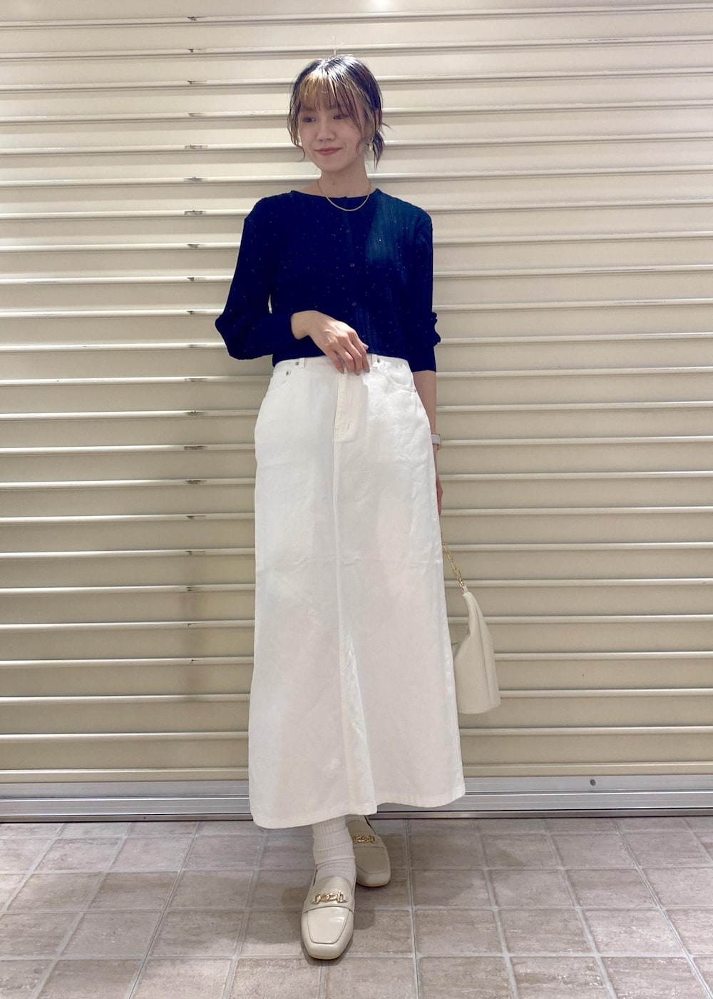 ホワイト系のローファー、ブルー系のカーディガン/ボレロ、ホワイト系のショルダーバッグを着用したレディースの冬コーディネートの2枚目の写真