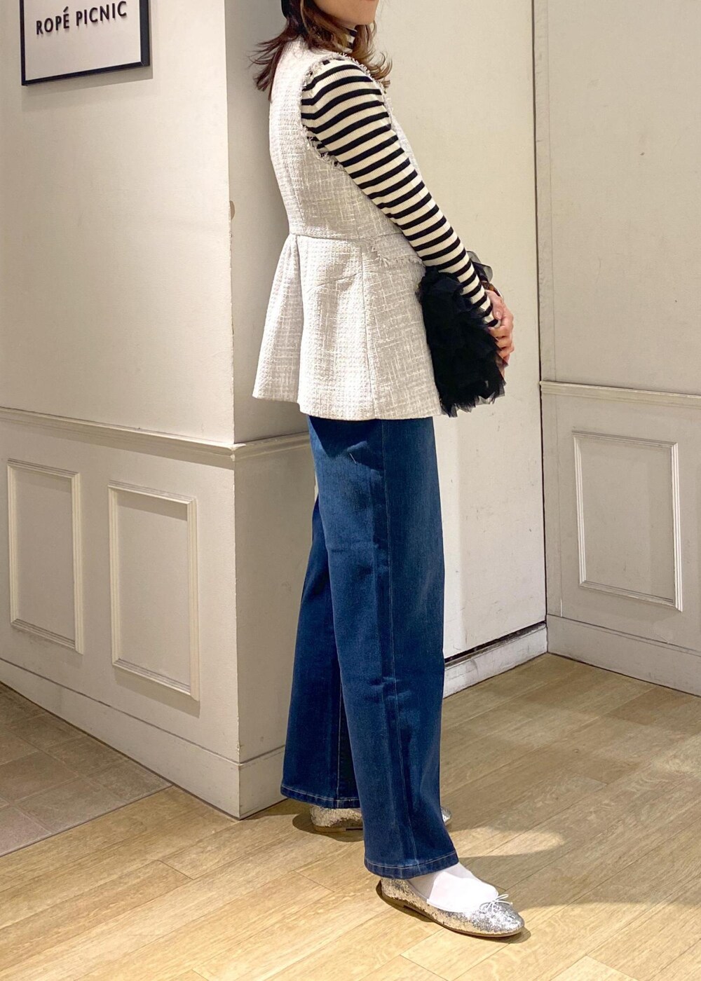 ブルー系のデニムパンツ、ブラック系のベスト、シルバー系のバレエシューズを着用したレディースの冬コーディネートの5枚目の写真