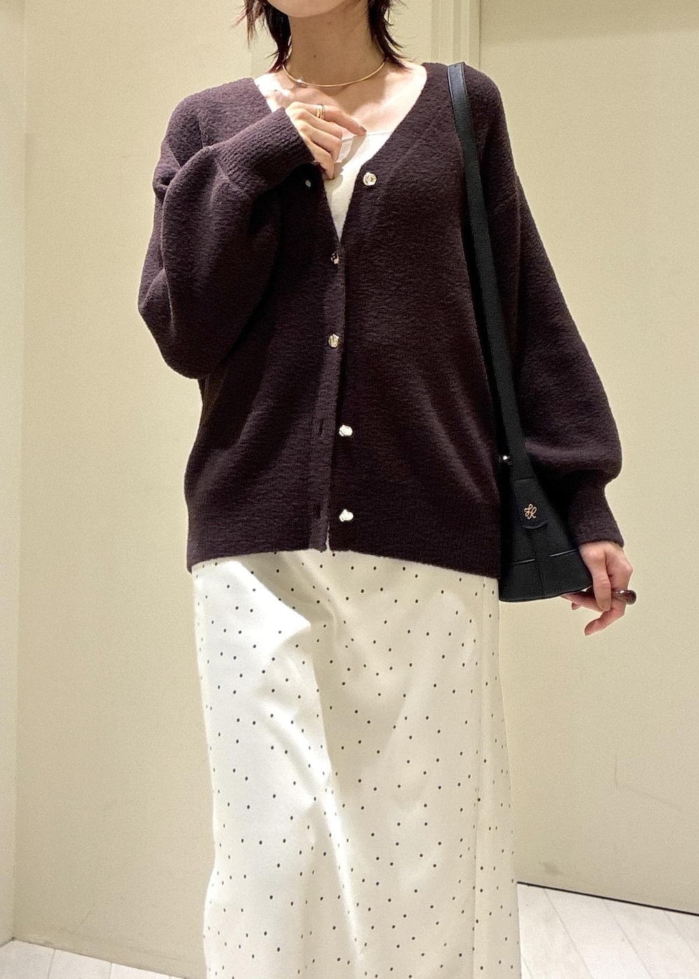 ブルー系のデニムパンツ、ブラック系のパンプス、ブラック系のショルダーバッグを着用したレディースの秋コーディネートの3枚目の写真