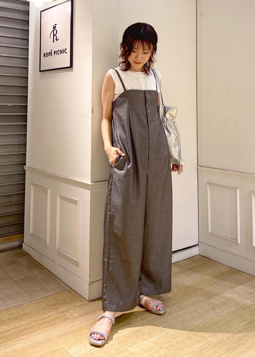 シルバー系のサンダル、ホワイト系のニット/セーター、シルバー系のトートバッグを着用したレディースの夏コーディネートの2枚目の写真