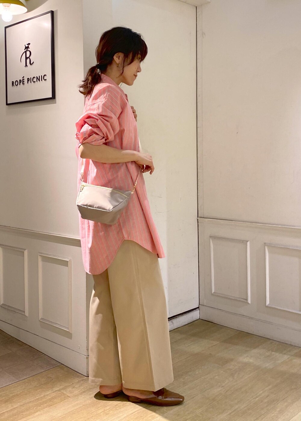 ベージュ系のチノパンツ、イエロー系のローファー、ベージュ系のショルダーバッグを着用したレディースの春コーディネートの4枚目の写真