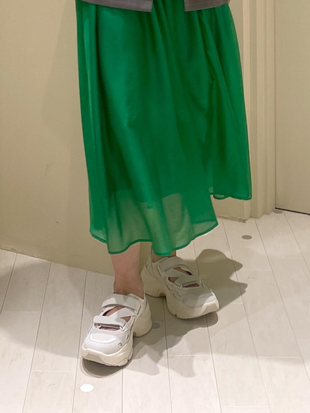 グリーン系のスカート、ホワイト系のTシャツ/カットソー、グレー系のテーラードジャケットを着用したレディースの夏コーディネートの7枚目の写真