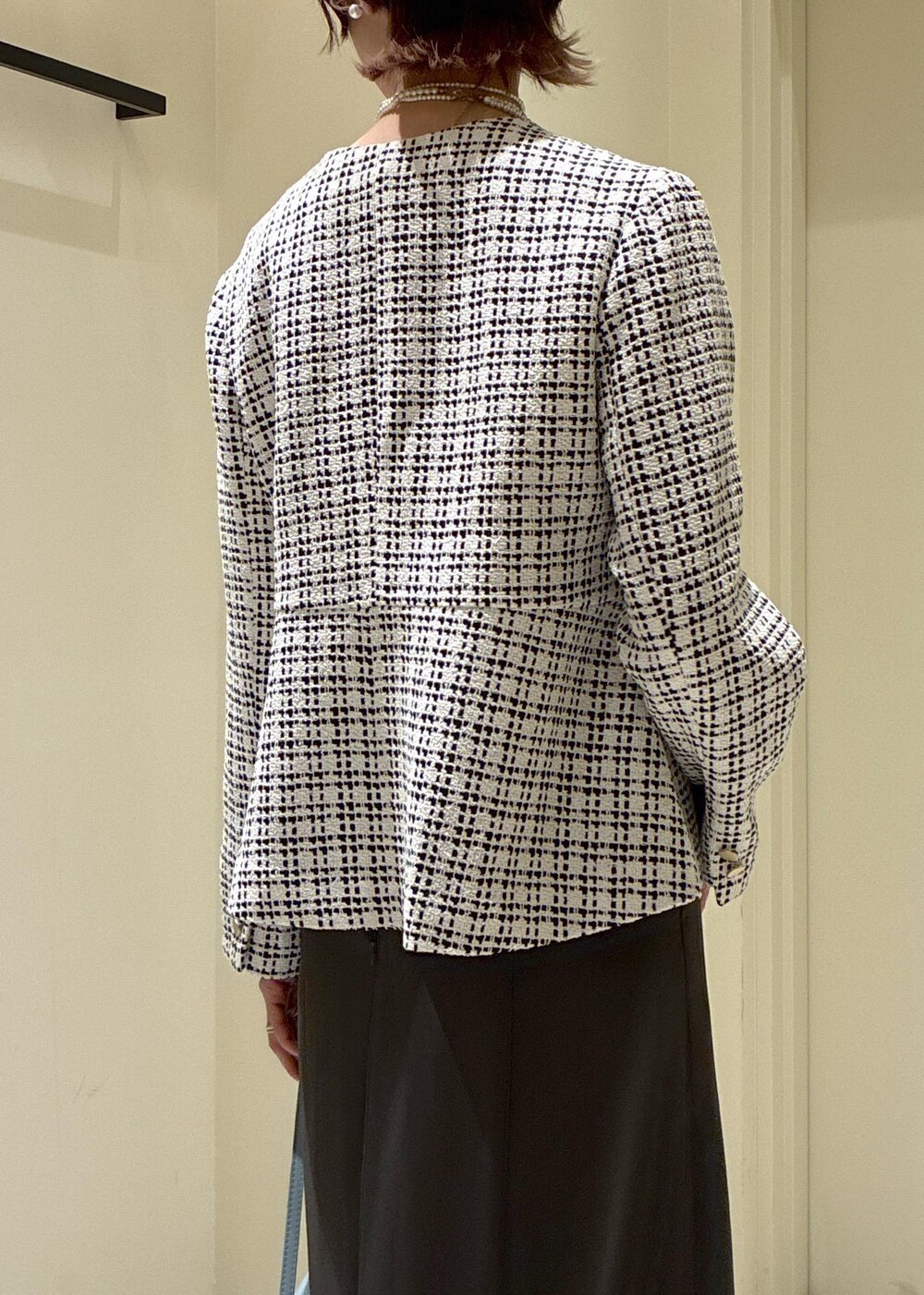 ブラック系のパンプス、ブルー系のショルダーバッグ、グレー系のドレスを着用したレディースの冬コーディネートの6枚目の写真