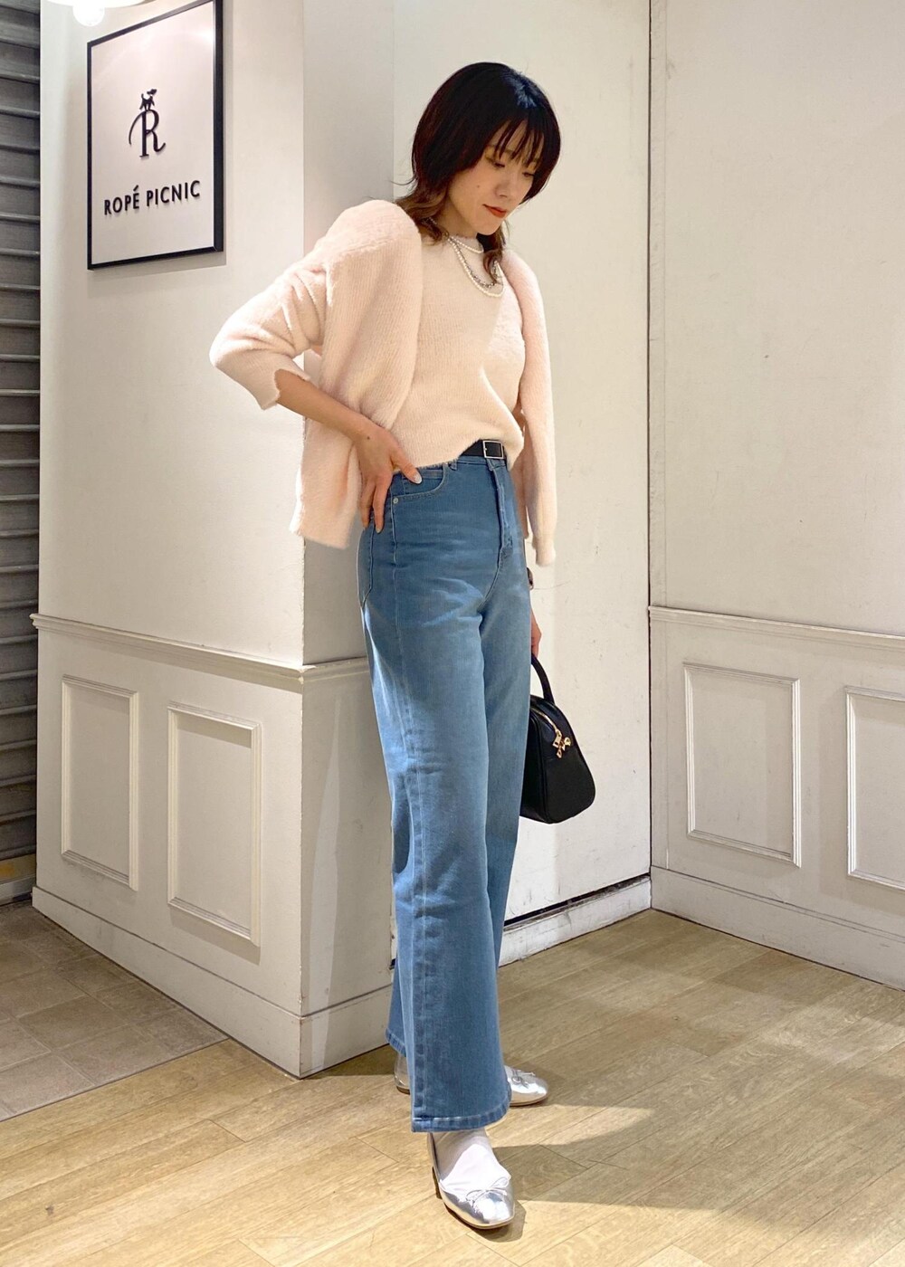 ブルー系のデニムパンツ、ピンク系のカーディガン/ボレロ、ピンク系のニット/セーターを着用したレディースの冬コーディネートの3枚目の写真