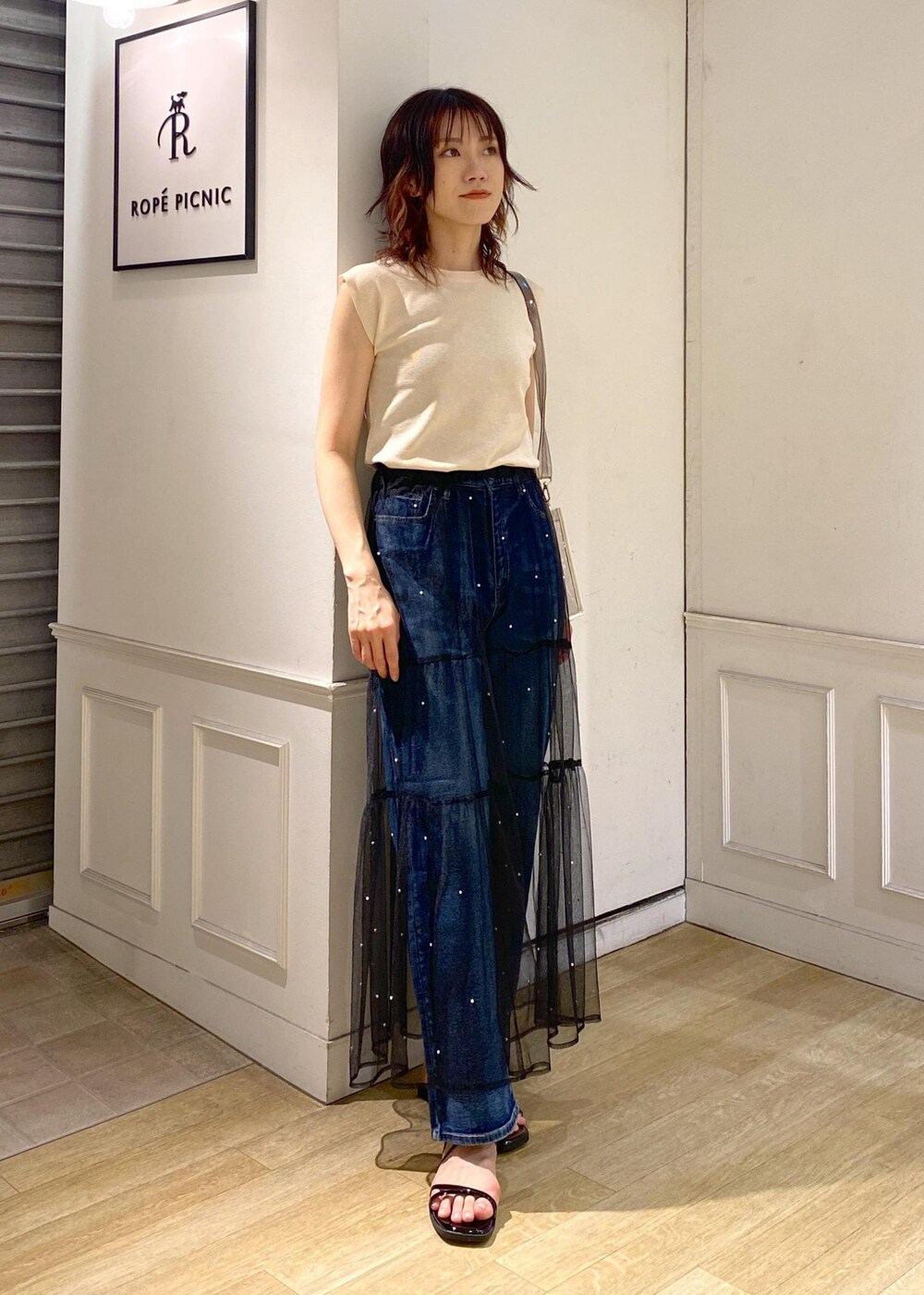 ブラック系のスカート、ブラック系のサンダル、ベージュ系のニット/セーターを着用したレディースの夏コーディネートの8枚目の写真