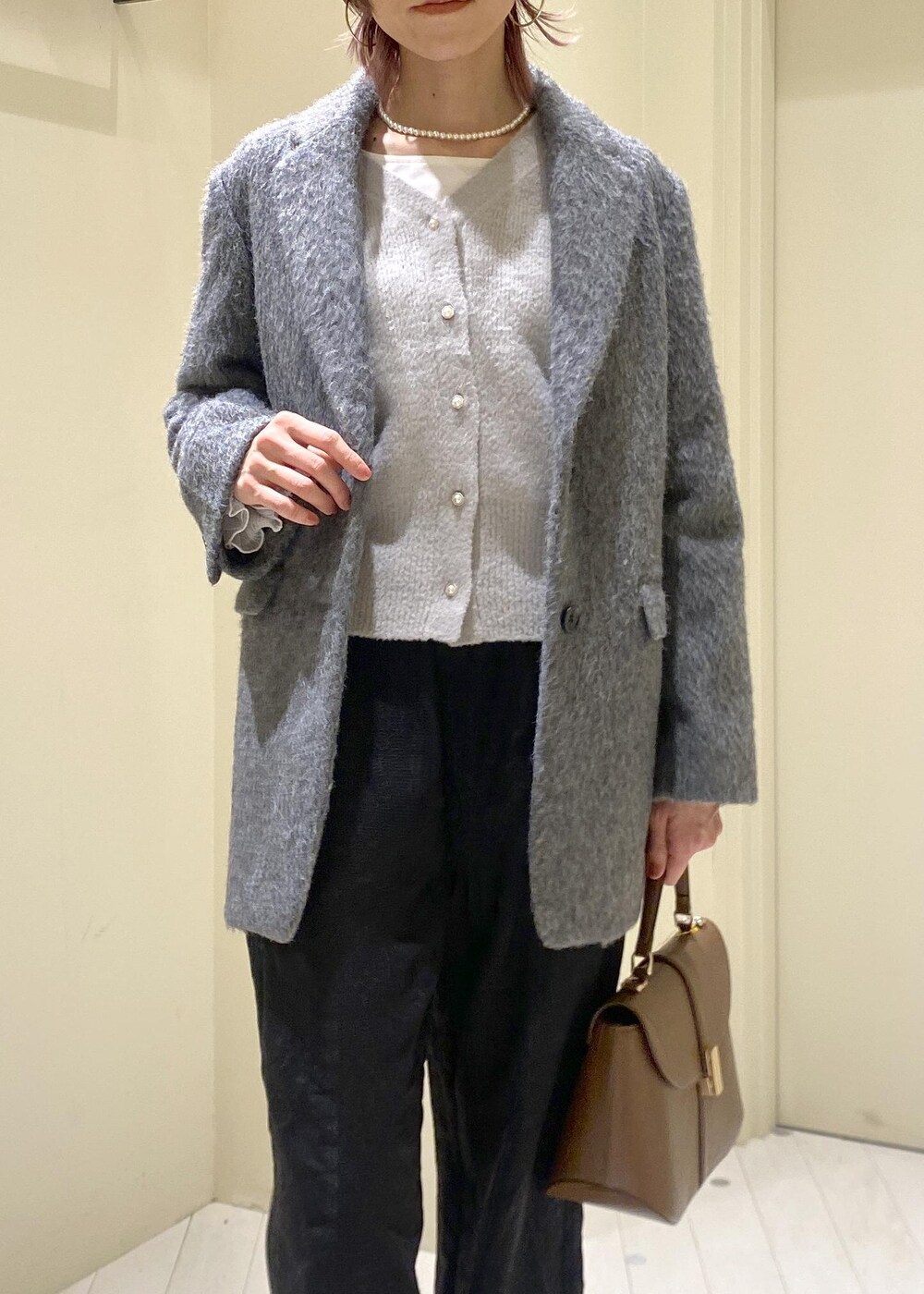 グレー系のカーディガン/ボレロ、ホワイト系のTシャツ/カットソー、グレー系のテーラードジャケットを着用したレディースの冬コーディネートの5枚目の写真