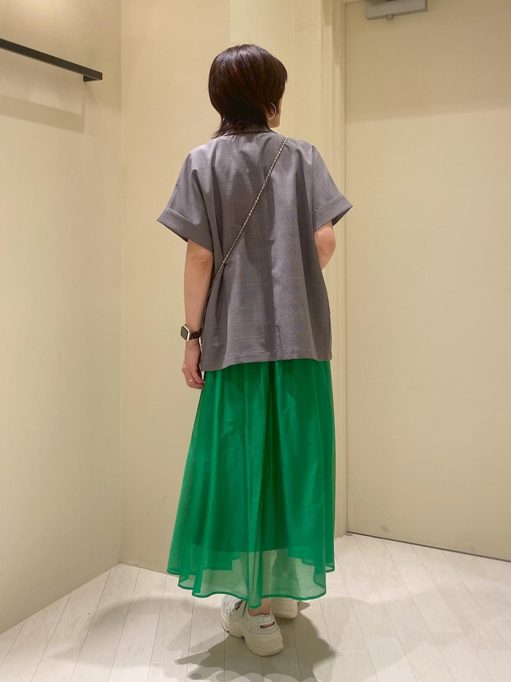 グリーン系のスカート、ホワイト系のTシャツ/カットソー、グレー系のテーラードジャケットを着用したレディースの夏コーディネートの2枚目の写真