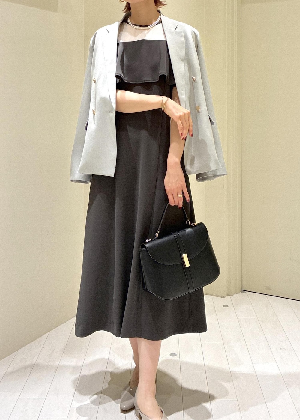 ベージュ系のパンプス、グレー系のドレス、グリーン系のテーラードジャケットを着用したレディースの冬コーディネートの6枚目の写真