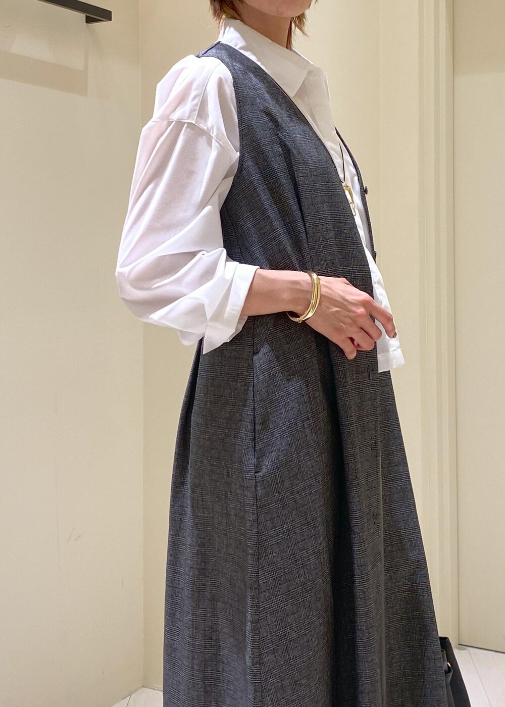 グリーン系のスカート、グレー系のジャンパースカート、ホワイト系のシャツ/ブラウスを着用したレディースの秋コーディネートの6枚目の写真