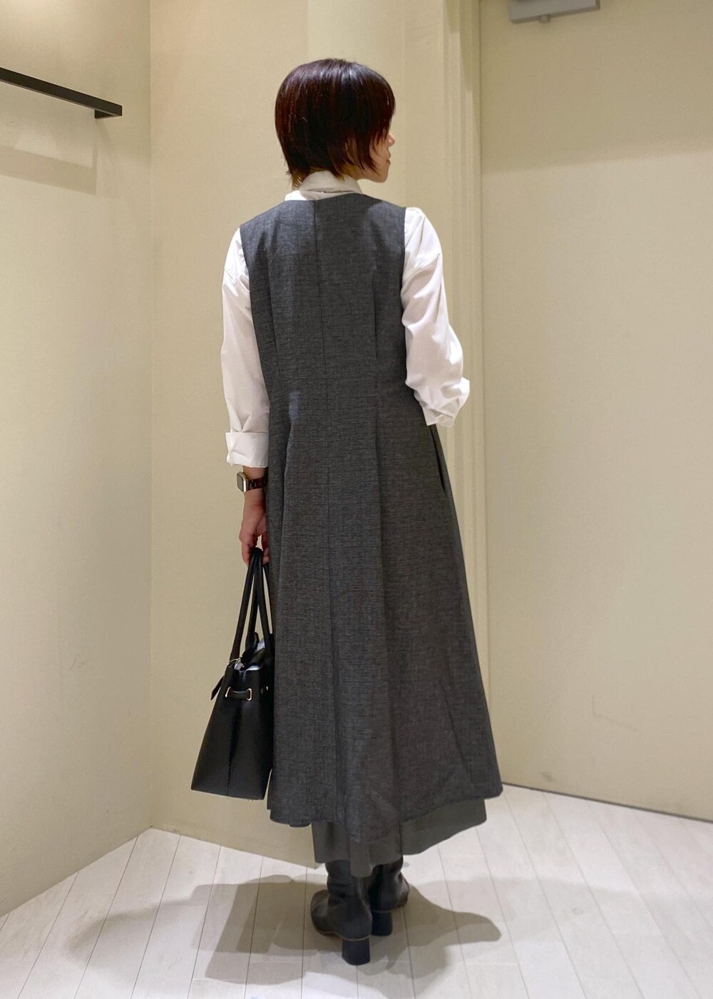 グリーン系のスカート、グレー系のジャンパースカート、ホワイト系のシャツ/ブラウスを着用したレディースの秋コーディネートの4枚目の写真