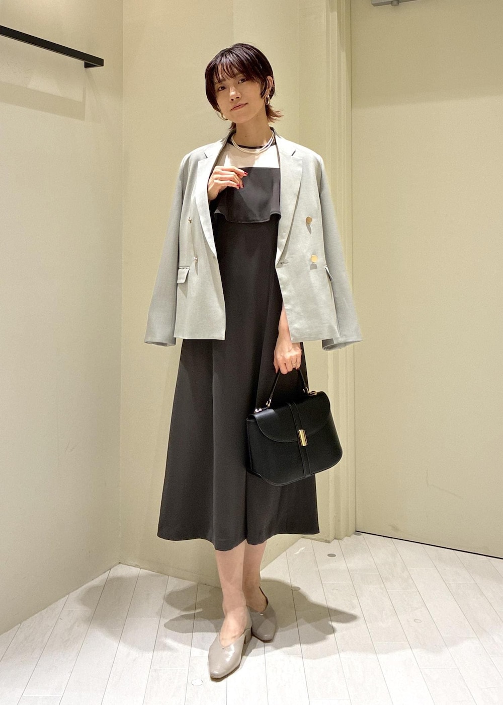 ベージュ系のパンプス、グレー系のドレス、グリーン系のテーラードジャケットを着用したレディースの冬コーディネートの5枚目の写真
