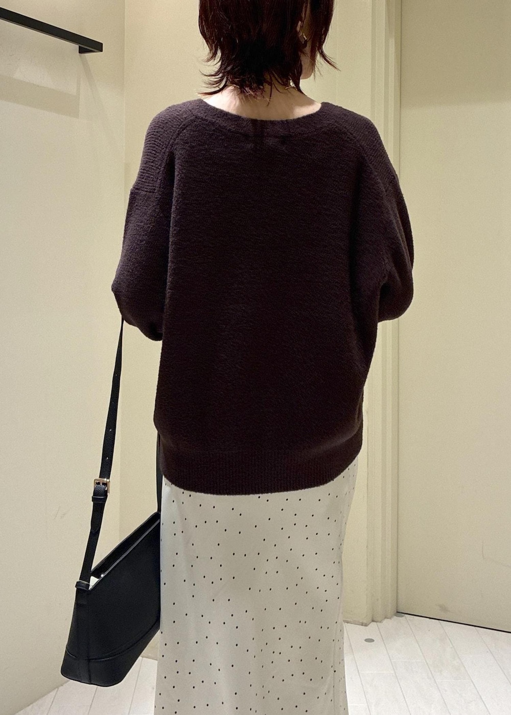 ブルー系のデニムパンツ、ブラック系のパンプス、ブラック系のショルダーバッグを着用したレディースの秋コーディネートの7枚目の写真