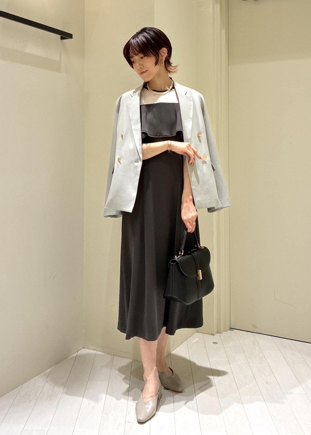 ベージュ系のパンプス、グレー系のドレス、グリーン系のテーラードジャケットを着用したレディースの冬コーディネートの8枚目の写真