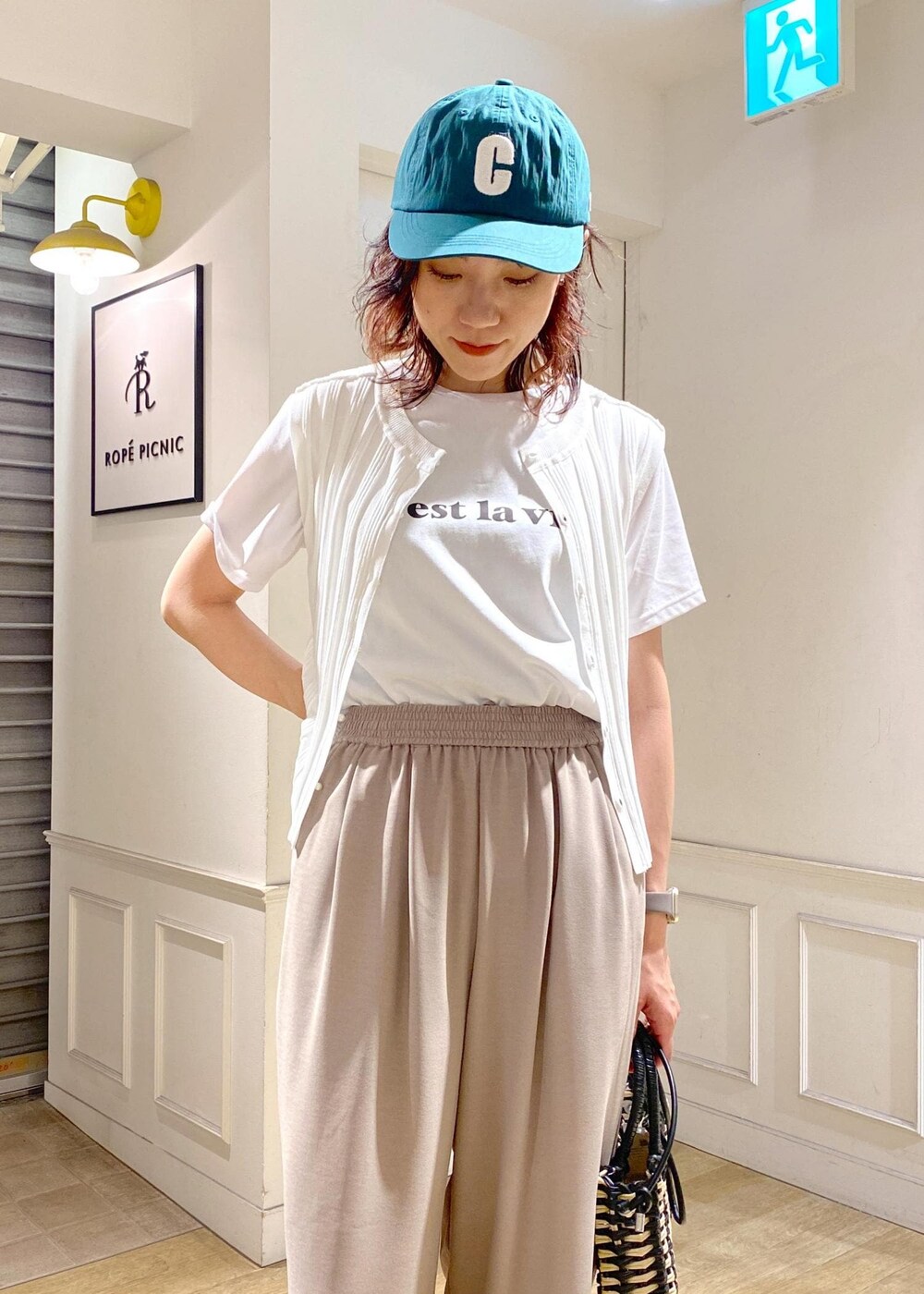 ホワイト系のニット/セーター、ホワイト系のサンダル、ベージュ系のその他パンツを着用したレディースの夏コーディネートの4枚目の写真