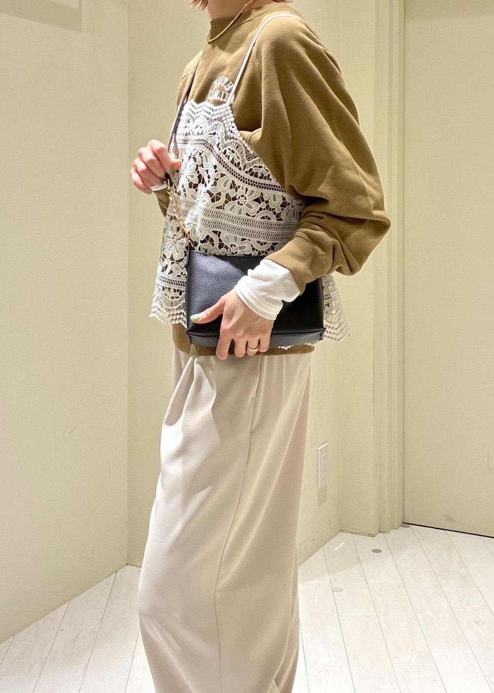 ブラック系のショルダーバッグ、ブラウン系のスウェット、ベージュ系のその他パンツを着用したレディースの春コーディネートの6枚目の写真