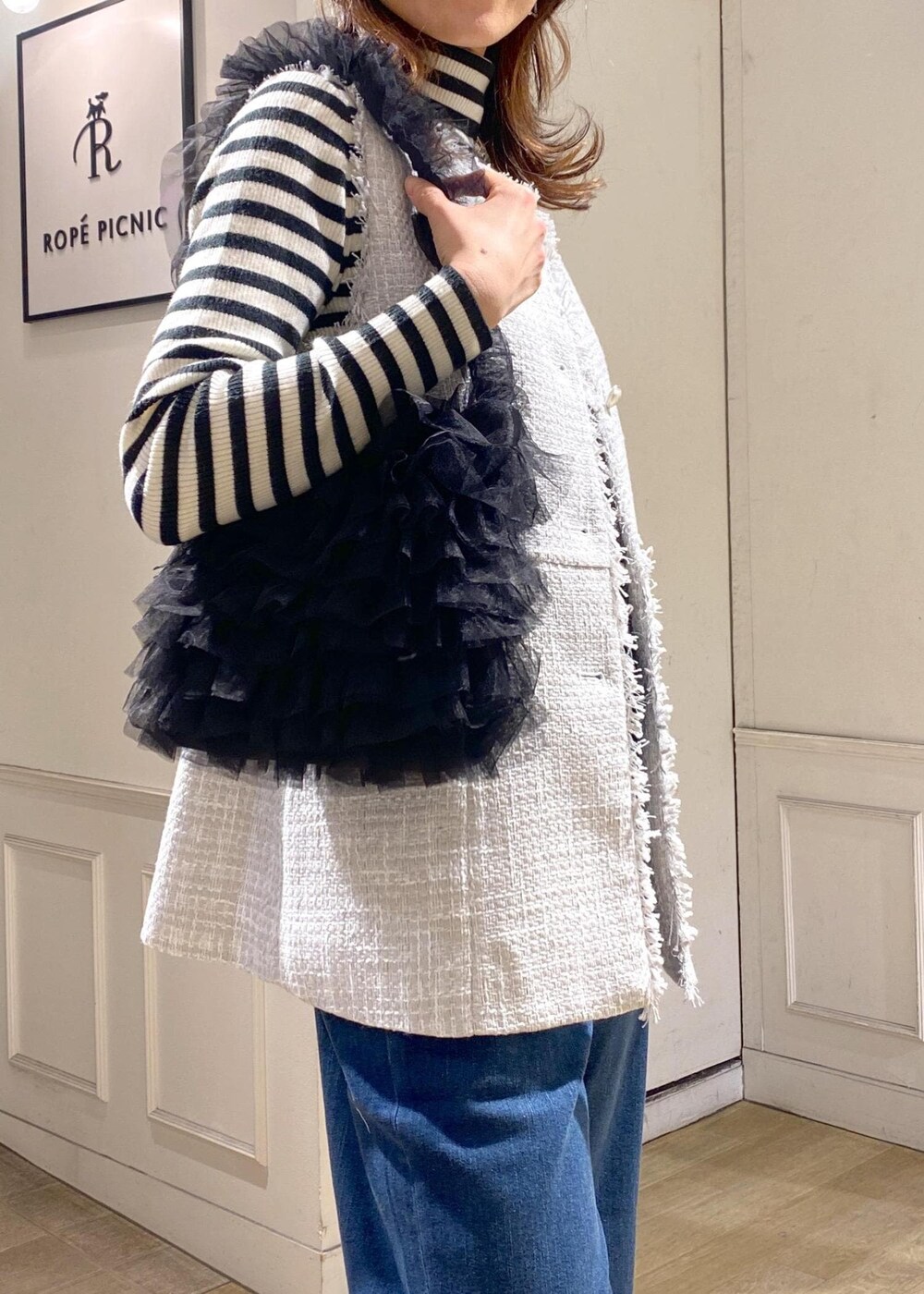 ブルー系のデニムパンツ、ブラック系のベスト、シルバー系のバレエシューズを着用したレディースの冬コーディネートの6枚目の写真