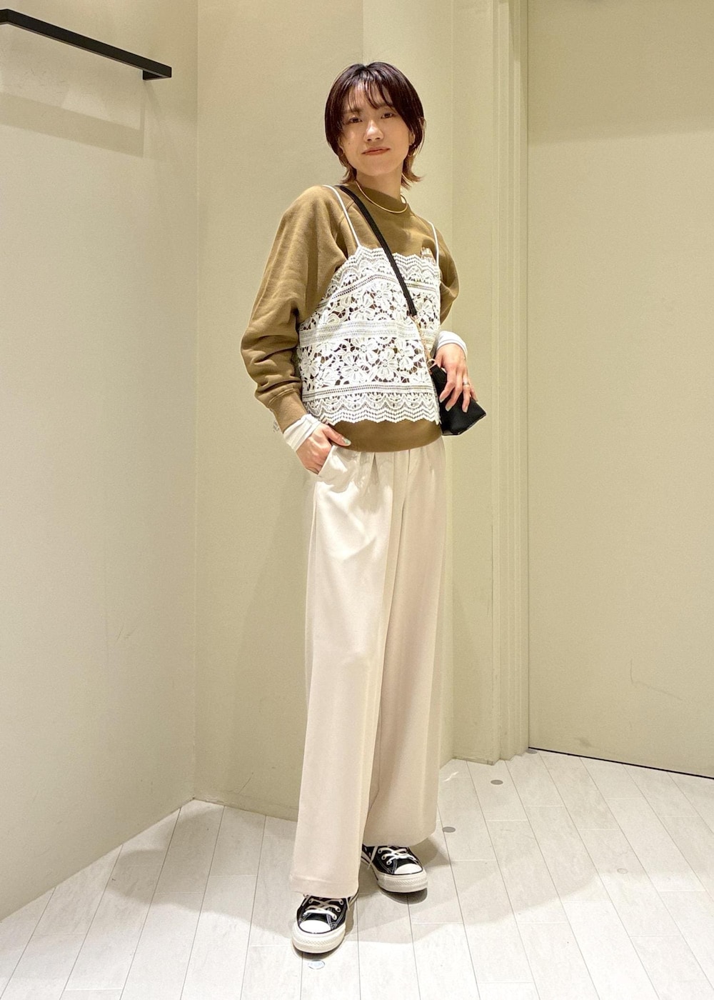 ブラック系のショルダーバッグ、ブラウン系のスウェット、ベージュ系のその他パンツを着用したレディースの春コーディネートの2枚目の写真