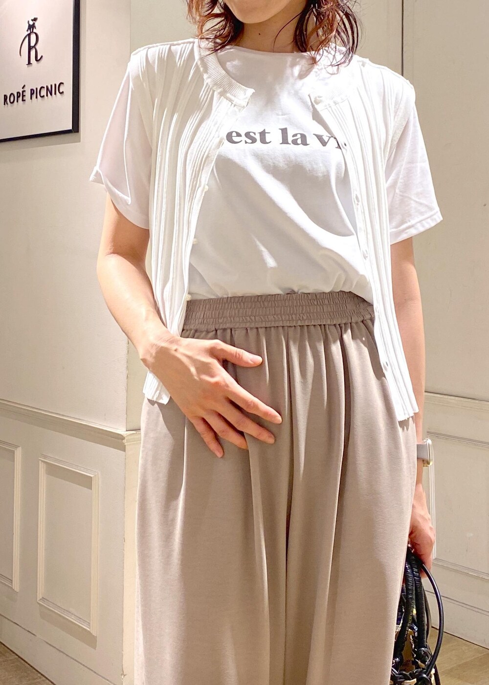 ホワイト系のニット/セーター、ホワイト系のサンダル、ベージュ系のその他パンツを着用したレディースの夏コーディネートの5枚目の写真