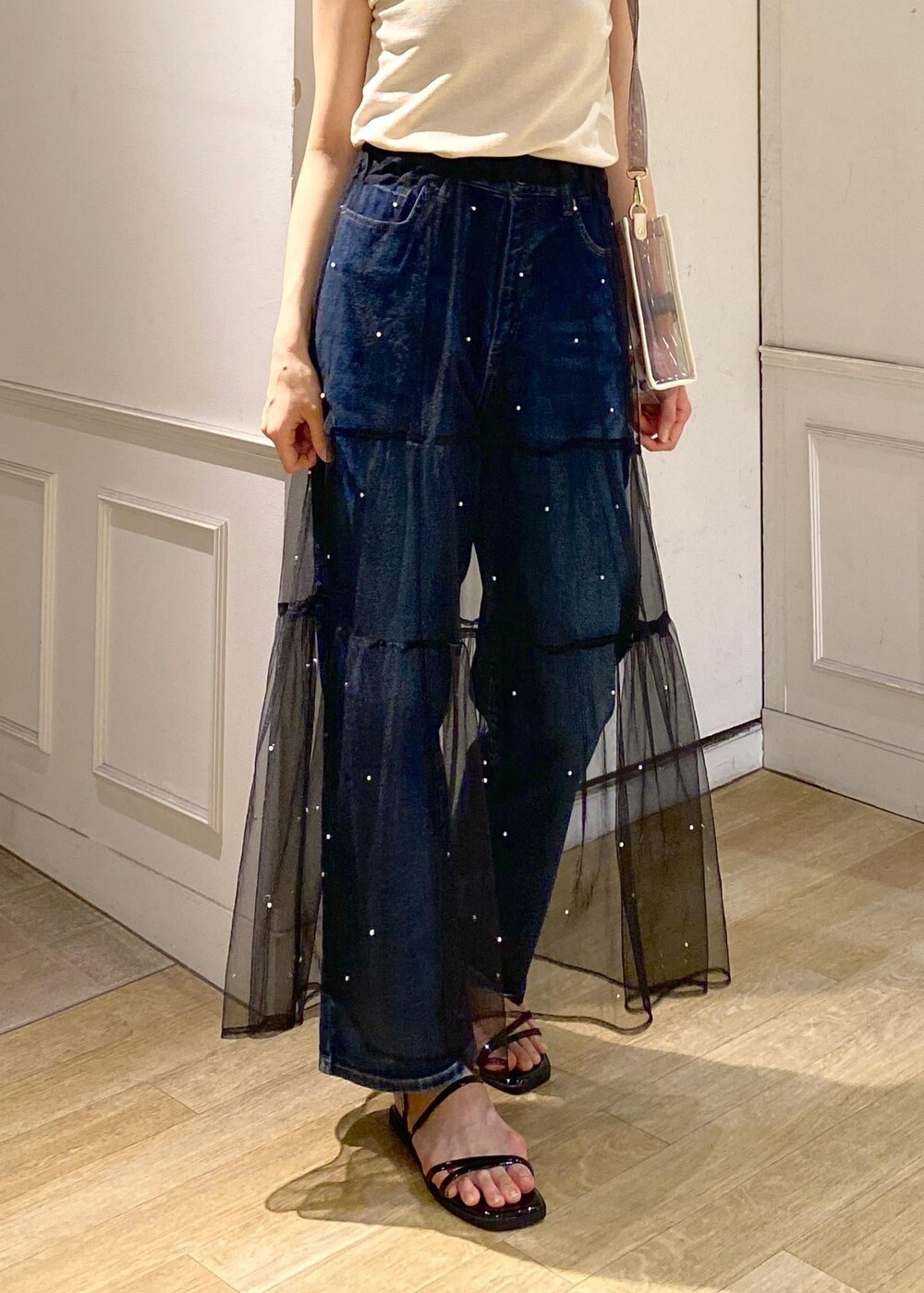 ブラック系のスカート、ブラック系のサンダル、ベージュ系のニット/セーターを着用したレディースの夏コーディネートの7枚目の写真