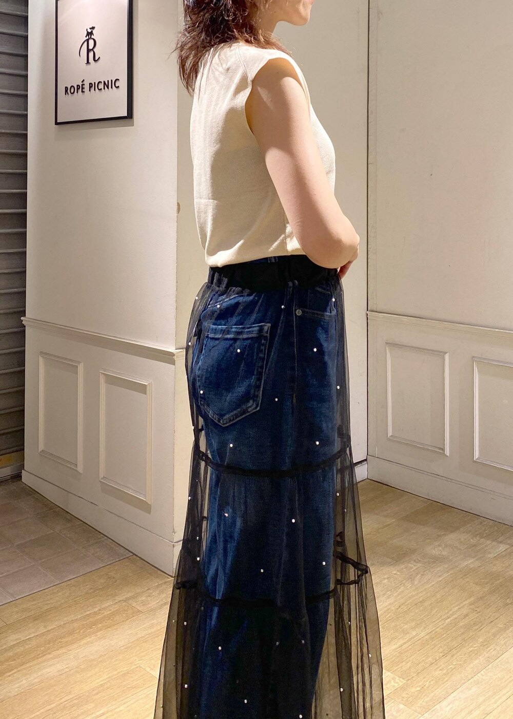 ブラック系のスカート、ブラック系のサンダル、ベージュ系のニット/セーターを着用したレディースの夏コーディネートの6枚目の写真