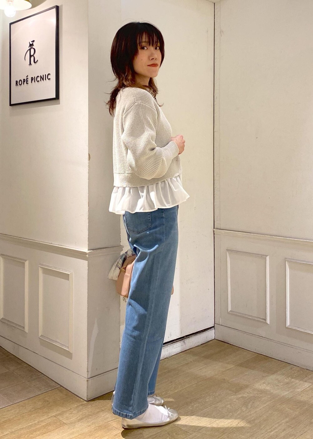 ブルー系のデニムパンツ、ピンク系のボストンバッグ、シルバー系のバレエシューズを着用したレディースの冬コーディネートの3枚目の写真