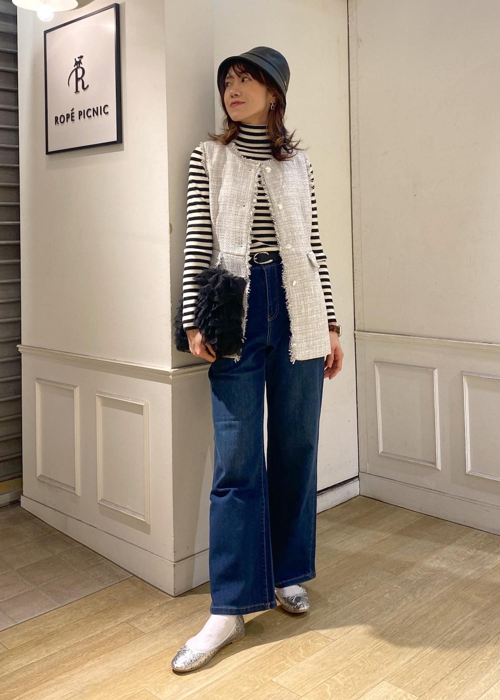 ブルー系のデニムパンツ、ブラック系のベスト、シルバー系のバレエシューズを着用したレディースの冬コーディネートの2枚目の写真