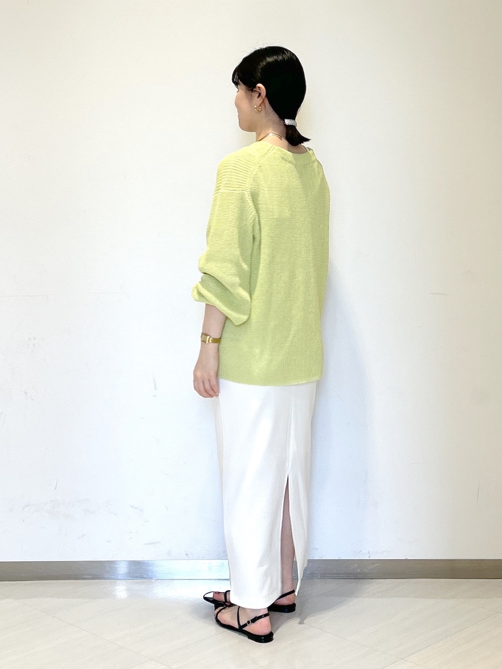 ホワイト系のタンクトップ、イエロー系のカーディガン/ボレロ、ホワイト系のスカートを着用したレディースの夏コーディネートの2枚目の写真