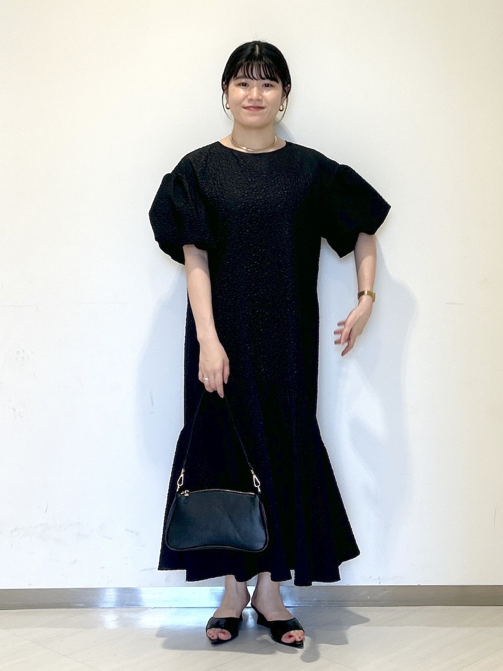 ブラック系のワンピース、ブラック系のサンダル、ブラック系のショルダーバッグを着用したレディースの夏コーディネートの5枚目の写真