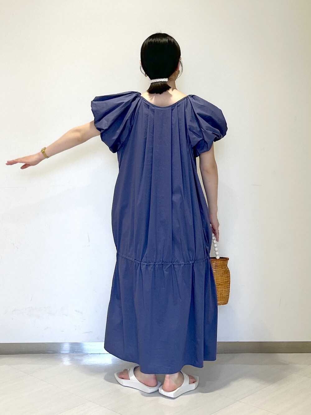 ブラウン系のかごバッグ、ホワイト系のサンダル、ブルー系のワンピースを着用したレディースの夏コーディネートの4枚目の写真