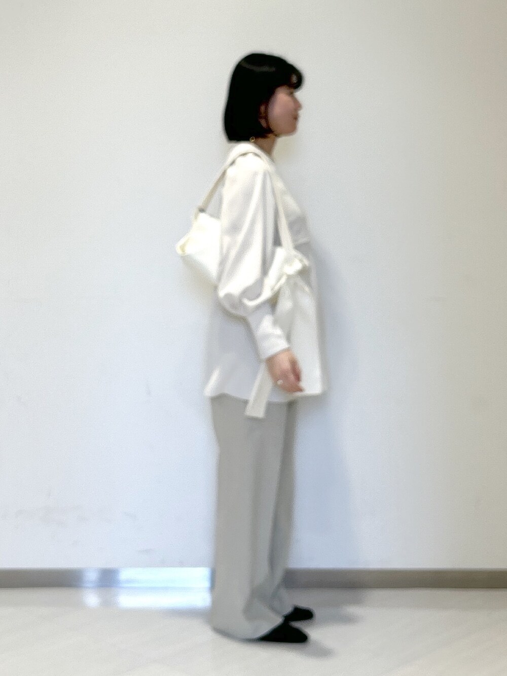 ホワイト系のシャツ/ブラウス、ホワイト系のショルダーバッグ、ベージュ系のスラックスを着用したレディースの春コーディネートの4枚目の写真