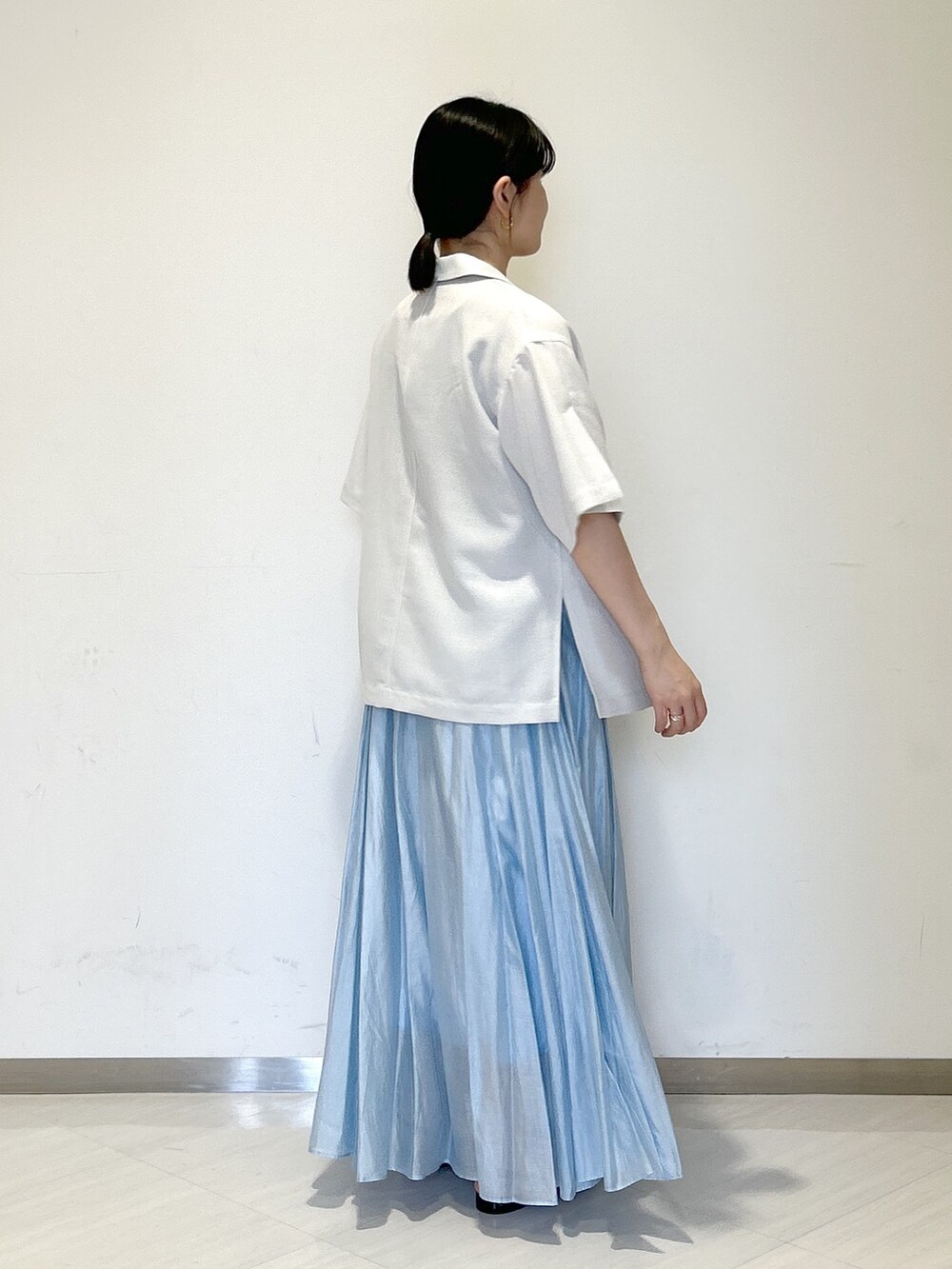 グレー系のテーラードジャケット、ブラック系のタンクトップ、ブラック系のショルダーバッグを着用したレディースの夏コーディネートの4枚目の写真