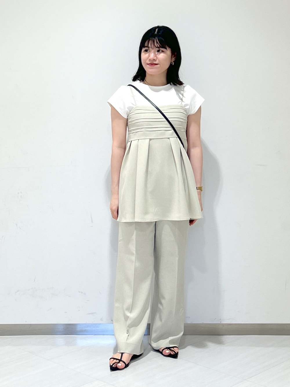 ベージュ系のスラックス、ブラック系のサンダル、ベージュ系のキャミソールを着用したレディースの夏コーディネートの5枚目の写真