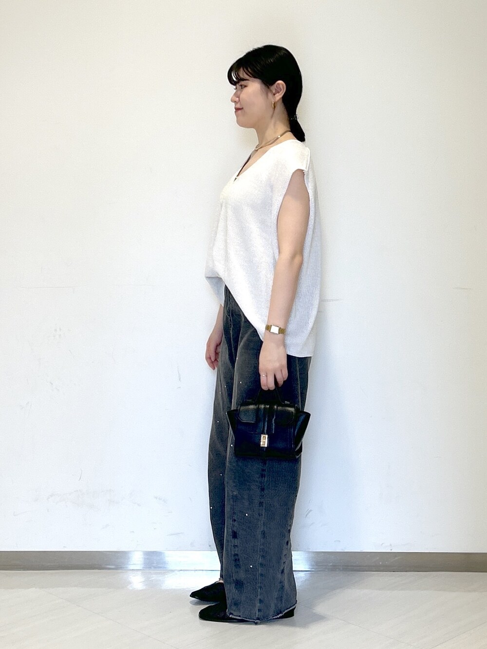 ベージュ系のキャミソール、ホワイト系のニット/セーター、ブラック系のショルダーバッグを着用したレディースの夏コーディネートの3枚目の写真