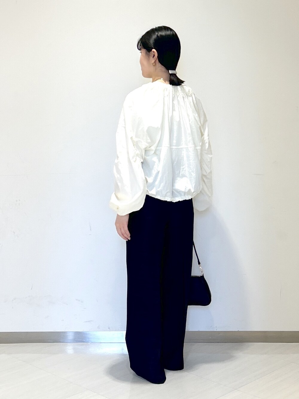 ホワイト系のTシャツ/カットソー、ホワイト系のブルゾン、ブラック系のその他パンツを着用したレディースの春コーディネートの4枚目の写真