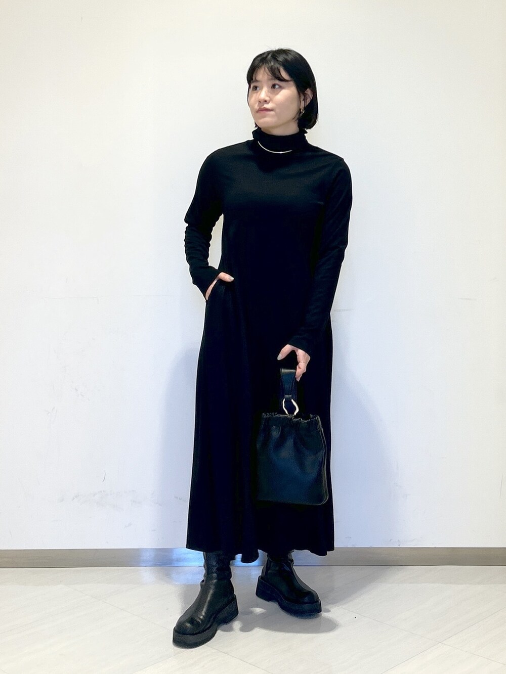 ホワイト系のワンピース、ブラック系のショルダーバッグ、グリーン系のカーディガン/ボレロを着用したレディースの冬コーディネートの5枚目の写真