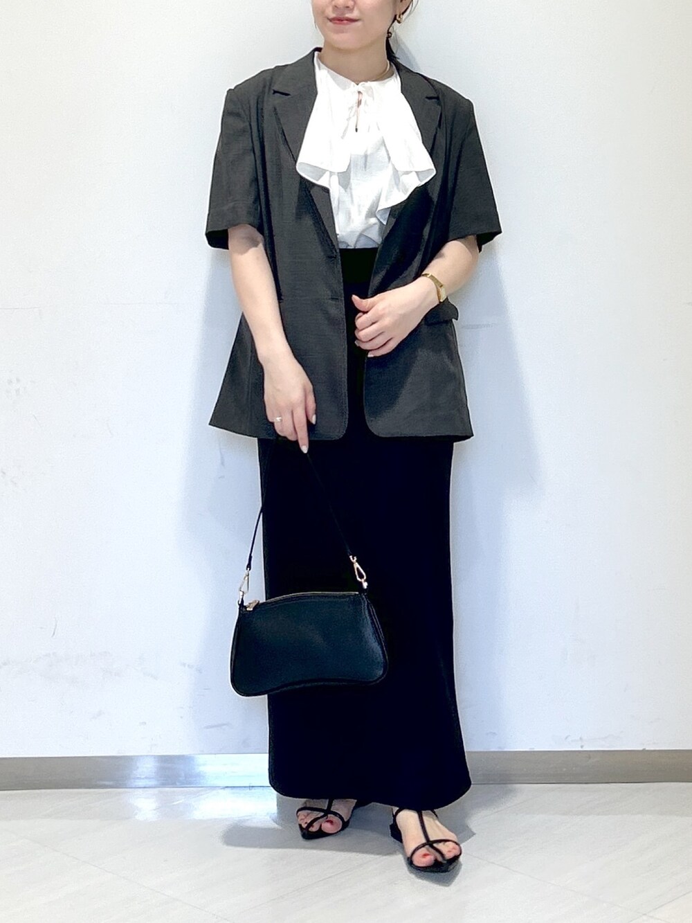 ホワイト系のシャツ/ブラウス、グレー系のテーラードジャケット、ブラック系のスカートを着用したレディースの夏コーディネートの2枚目の写真