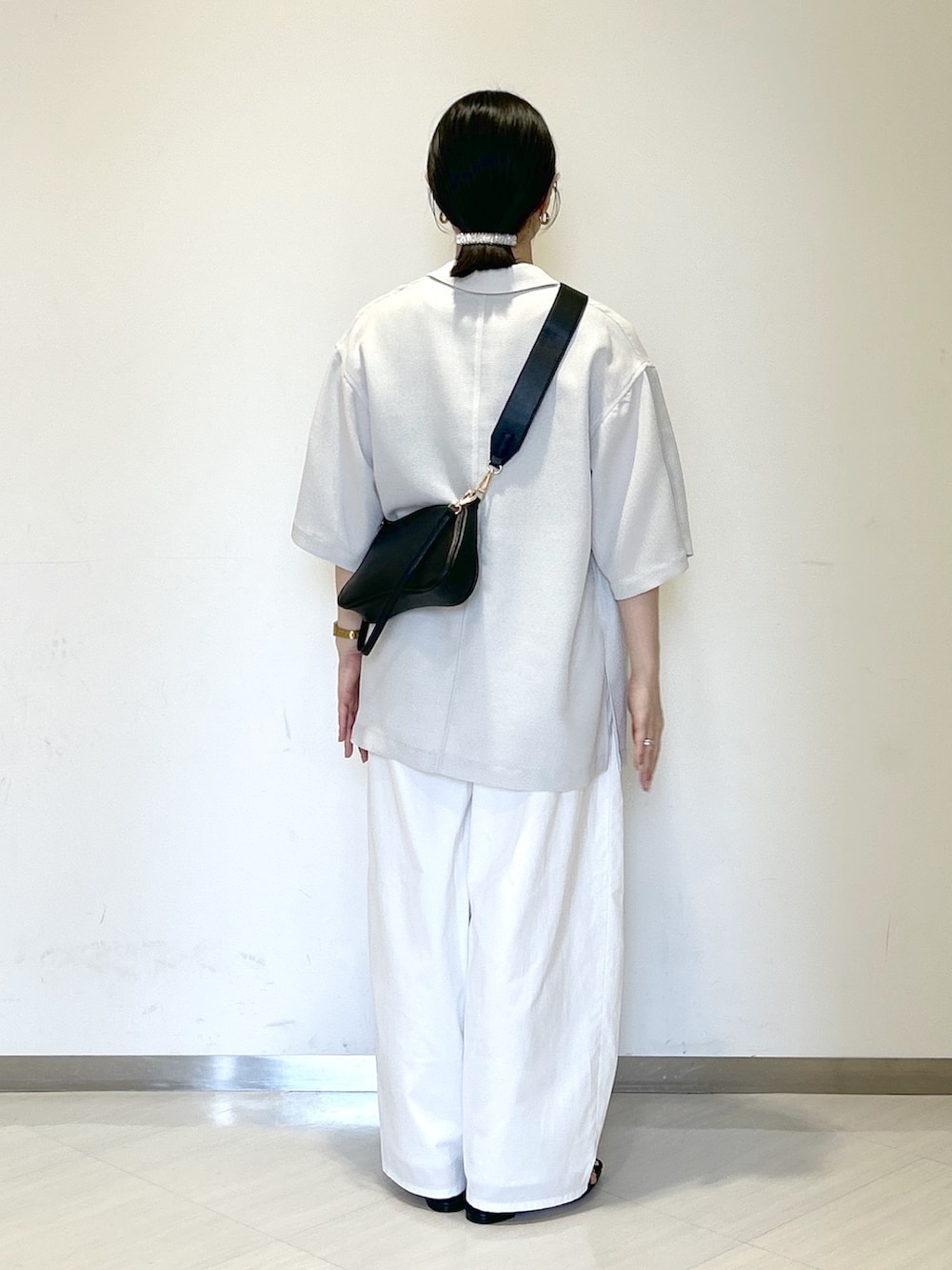 グレー系のタンクトップ、ブラック系のショルダーバッグ、グレー系のテーラードジャケットを着用したレディースの夏コーディネートの3枚目の写真