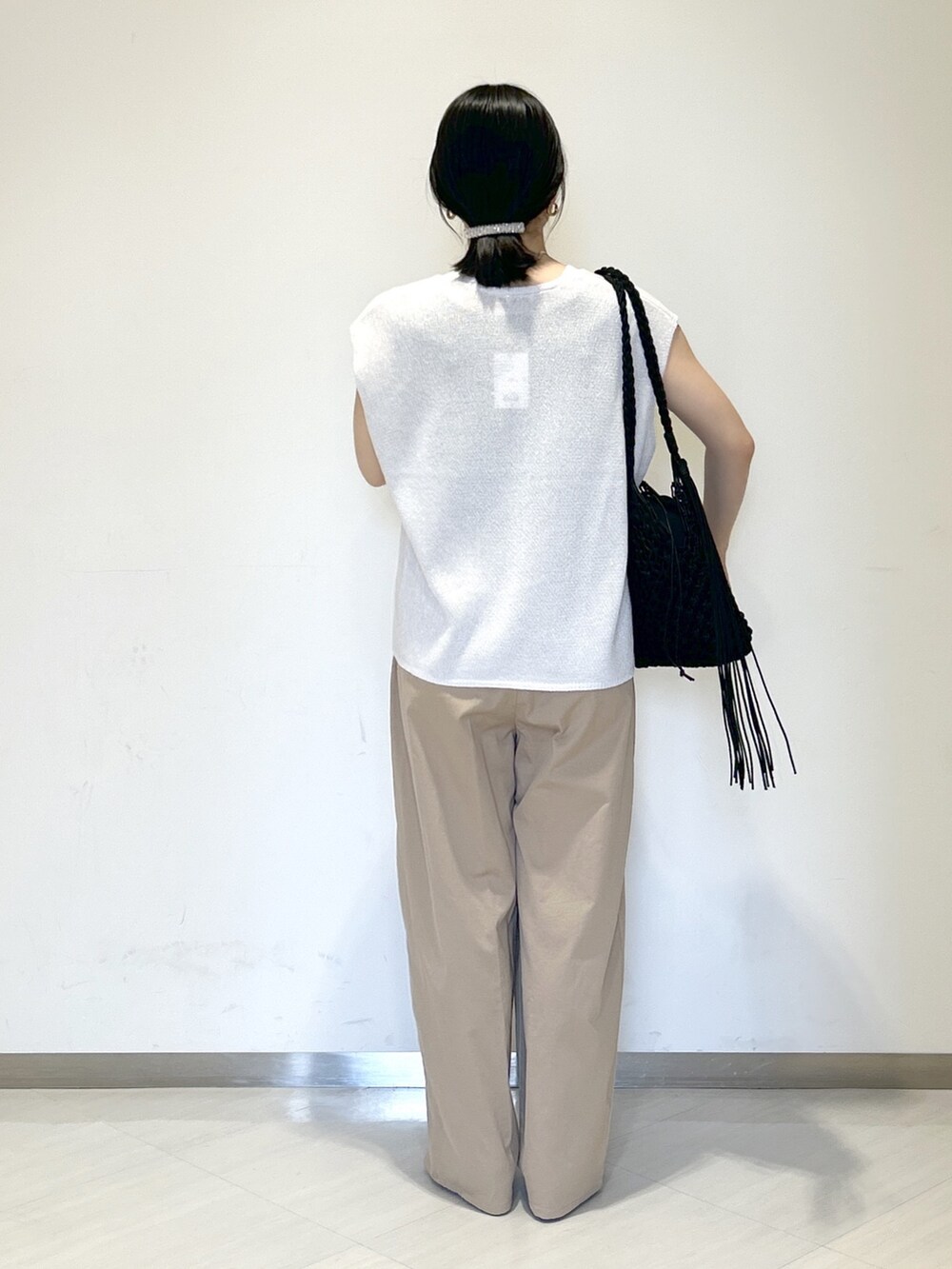 ブラック系のタンクトップ、ブラック系のショルダーバッグ、イエロー系のその他パンツを着用したレディースの夏コーディネートの4枚目の写真