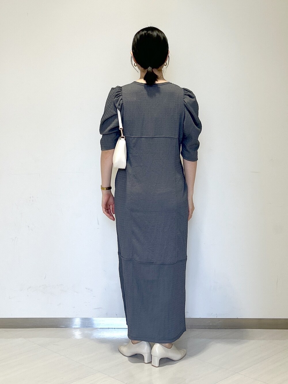 ベージュ系のパンプス、ホワイト系のショルダーバッグ、グレー系のワンピースを着用したレディースの夏コーディネートの4枚目の写真