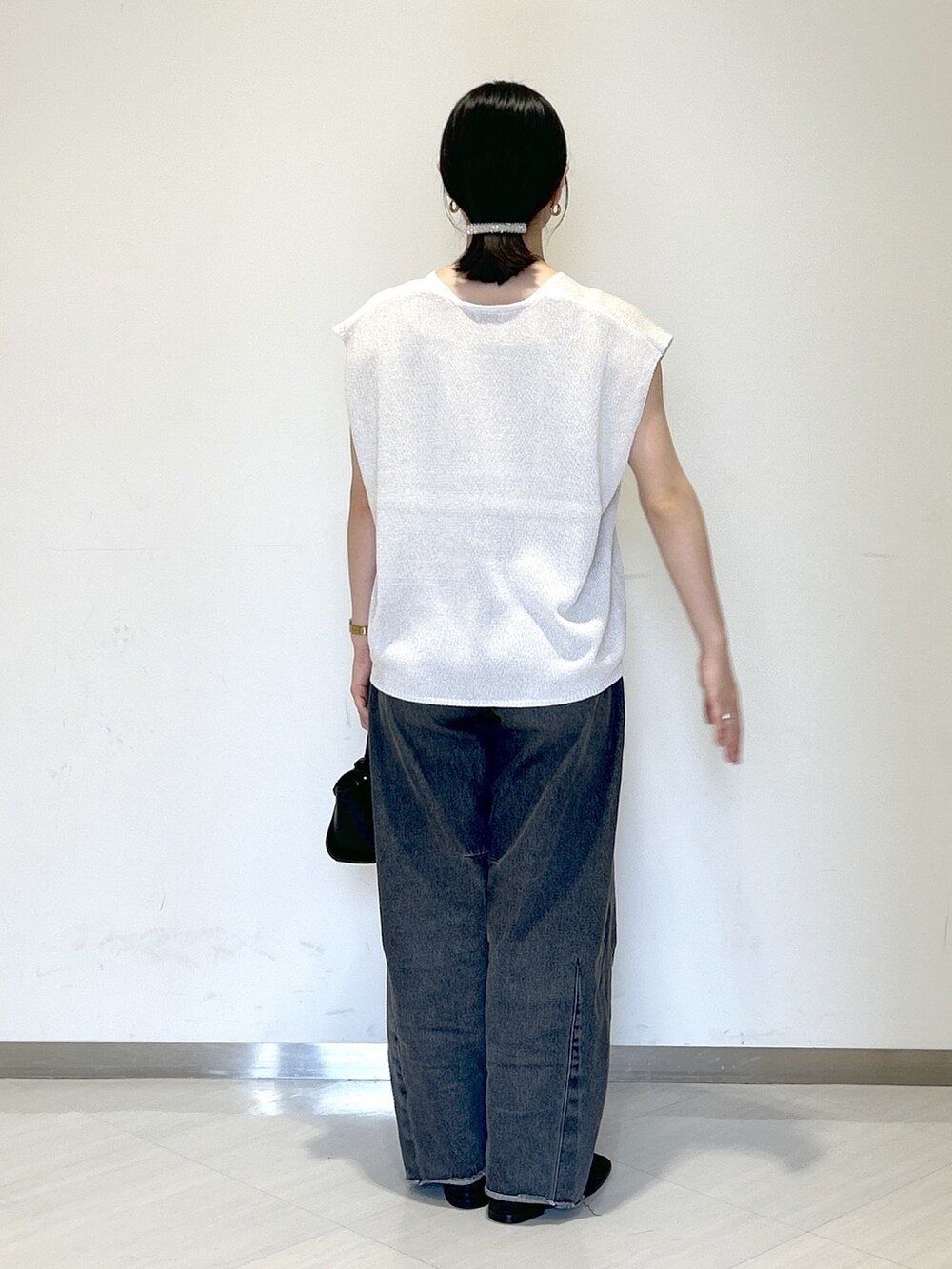 ベージュ系のキャミソール、ホワイト系のニット/セーター、ブラック系のショルダーバッグを着用したレディースの夏コーディネートの4枚目の写真