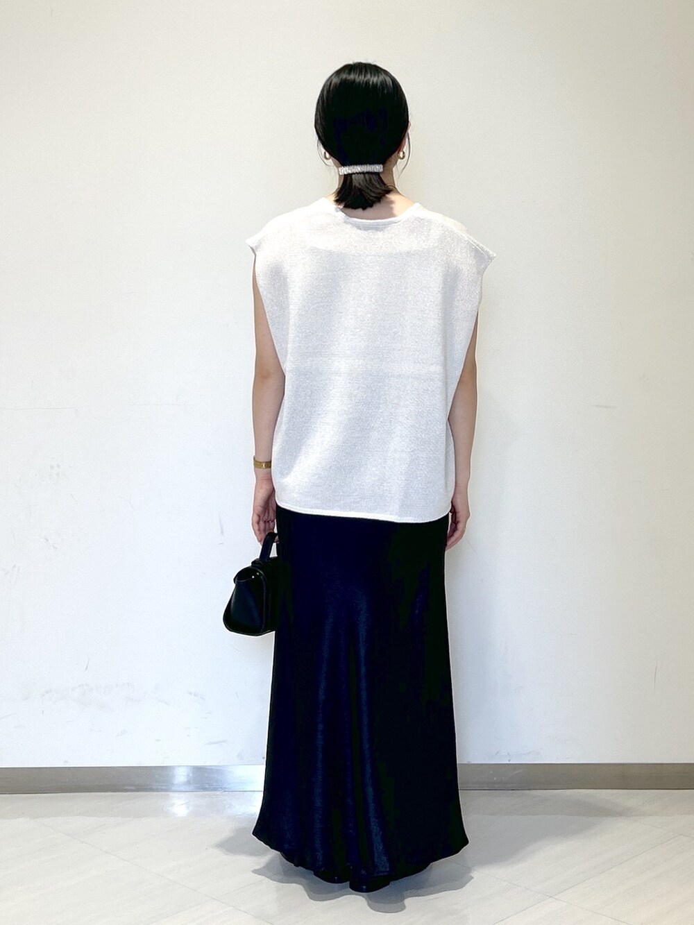 ベージュ系のキャミソール、ホワイト系のニット/セーター、ブラック系のショルダーバッグを着用したレディースの夏コーディネートの4枚目の写真