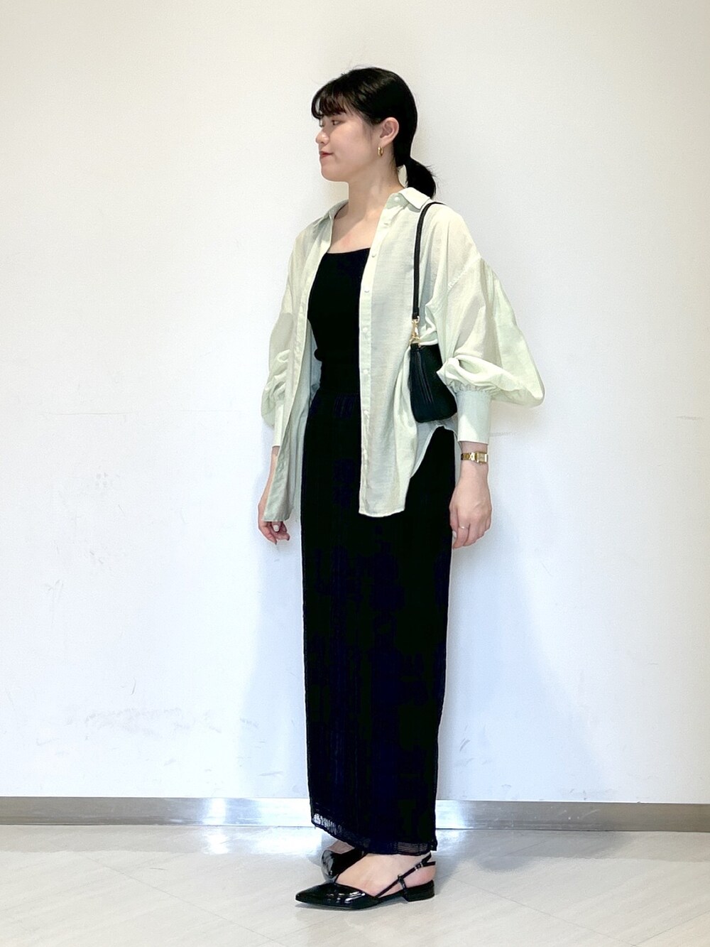 ブラック系のショルダーバッグ、ブラック系のタンクトップ、グリーン系のシャツ/ブラウスを着用したレディースの夏コーディネートの2枚目の写真